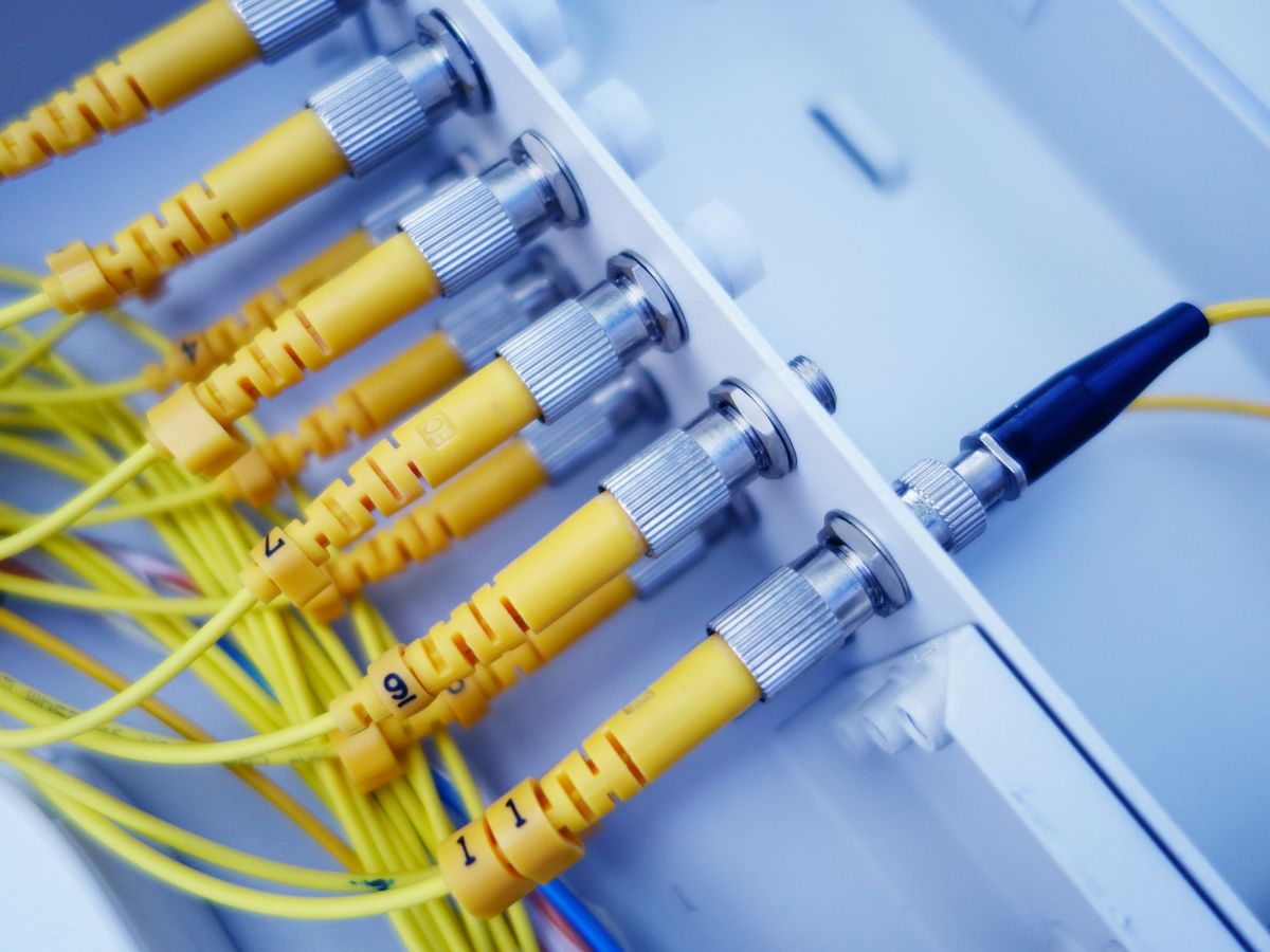 Organized yellow fiber optic cables in network infrastructure
